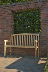 Bench in a park with a brick wall in the background