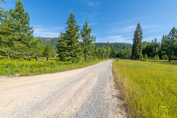 Fototapeta na wymiar A long gravel road through the North Idaho panhandle mountains of Spirit Lake, Idaho, in the Bonner County, on a summer day.