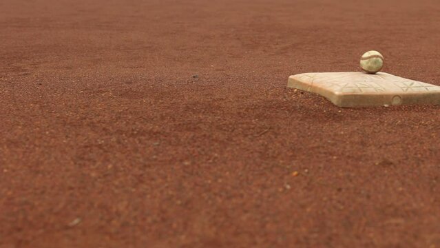 Camera moves across baseball base with ball