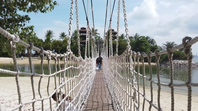 walking through long rope wooden bridge palawan beach singapore