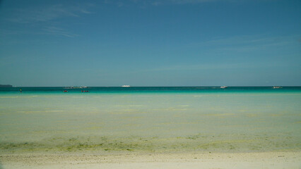 Seascape: blue sea and tropical beach on a background of blue sky. Summer and travel vacation...