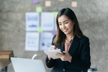 Asian woman working with laptop in her office. business financial concept.