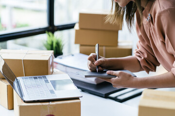 Starting small businesses SME owners female entrepreneurs check online orders to prepare to pack...