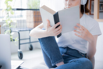 明るい室内で読書をする日本人女性