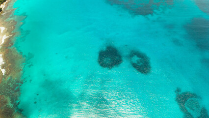 Sea water surface in lagoon with coral reef copy space for text, aerial view. Top view transparent turquoise ocean water surface. background texture