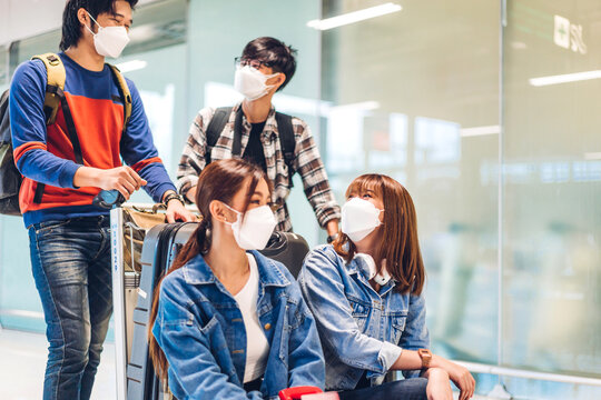 Young friend traveler in quarantine for coronavirus wearing surgical mask face protection with luggage look flight travel before long travel vacation flight at International terminal airport