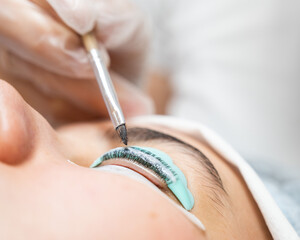 Close-up portrait of a woman on eyelash lamination procedure. 