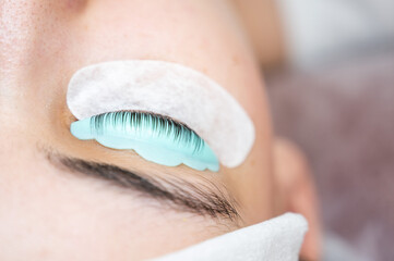 Close-up portrait of a woman in a beauty salon on eyelash lamination procedure. 