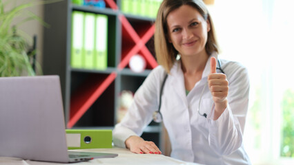 Happy smiling female practitioner showing thumb up gesture