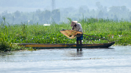 Life of a  fisherman with his canoe fishing in the Lake Loktak of Manipur