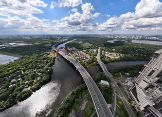 panoramic view of the red bridge over the river on the freeway on a sunny day taken from a drone