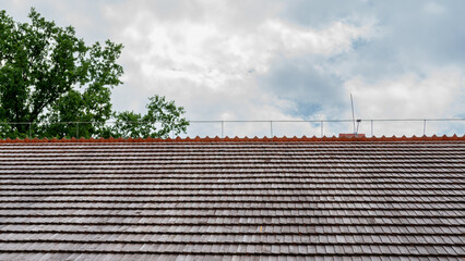 Shingled roof with a lightning protection system on the ridge. Polish traditional house - obrazy, fototapety, plakaty