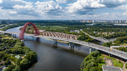 panoramic view of the red bridge over the river on the freeway on a sunny day taken from a drone