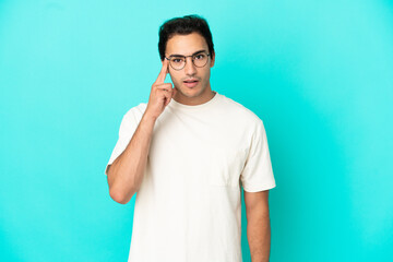 Caucasian handsome man over isolated blue background thinking an idea