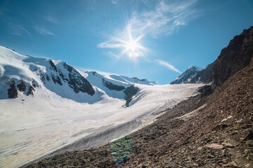 Scenic mountain landscape with large glacier in sunlight. Awesome scenery with glacial tongue under...