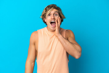 Handsome blonde man isolated on blue background with surprise and shocked facial expression