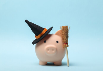 Halloween Piggy bank witch hat and a broom on a blue background