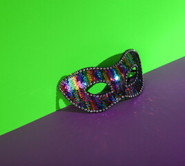 Fototapeta premium Carnival mask on green-purple background. Creative layout.