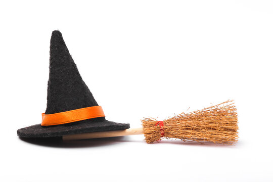 Halloween witch's broom and hat isolated on white background