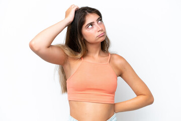Obraz premium Young caucasian woman isolated on white background having doubts while scratching head