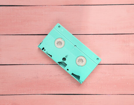 Minimalism creative layout. Pink video cassette on pink wooden background. Minimalism. Top view. Flat lay