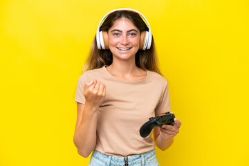 Young caucasian woman playing with a video game controller isolated on yellow background inviting to come with hand. Happy that you came