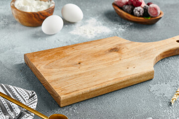 Food mockup. Empty wooden board on concrete table with pastry ingredients. Wooden board  with...