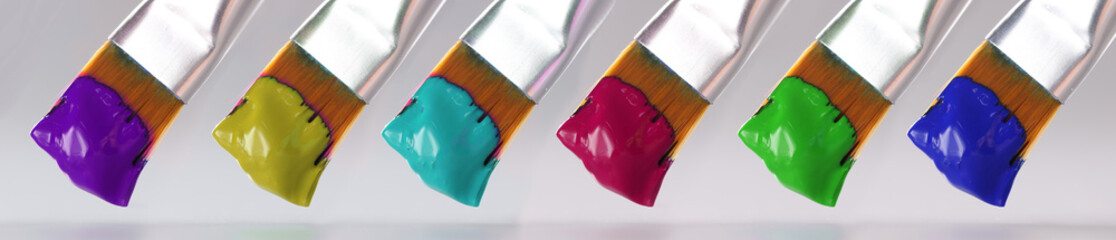 Three brushes with different paint colors closeup