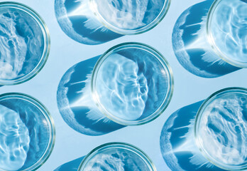 petri dish with liquid water on plain blue background water ripple texture