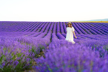 Young woman in a white dress walking in a lavender field
