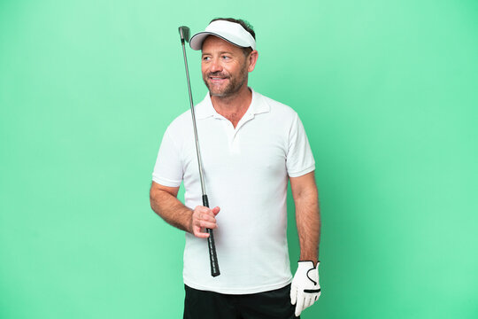 Middle Age Caucasian Man Isolated On Green Background Playing Golf