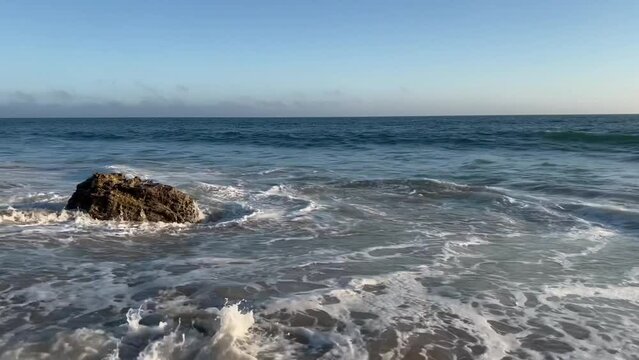 4k Malibu Beach Blue and Green Ocean waves crash into the shore on a cloudy day b roll
