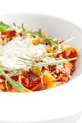 Italian pasta pappardelle with bolognese sauce  and parmesan isolated on white background. Pasta tagliatelle with meat ragu and creamy espuma with arugula. Minced beef in tomato sauce with pasta.
