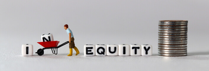 White cube with the word 'EQUITY'. A miniature man carrying a white cube with an 'IN' on it in a...