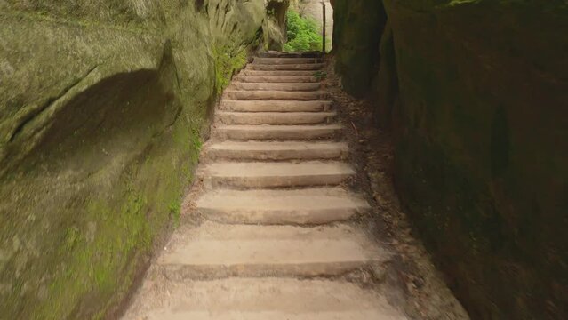 POV from the ascent over rough-hewn stone steps of the stairs next to the towering rocks of the rock garden of Adersbach, Czech Republic