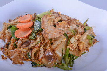 Stir-fried Noodles in Sweet Soy Sauce with Pork ( Pad See-Ew ) on white bowl for Thai food 