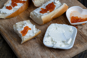 making sandwiches with baguette and cream cheese with caviar