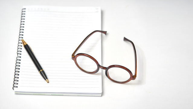 minimal notebook glasses and pen on white table - Powered by Adobe