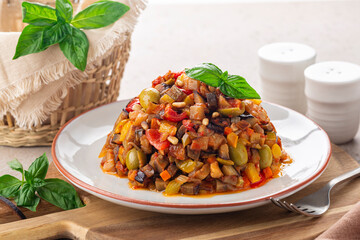 Caponata siciliana - italian, sicilain stew consisting of chopped fried aubergine oe eggplant and other  vegetables like celery, omion, olives, bell pepper, tomato and toasted pine nuts. - obrazy, fototapety, plakaty