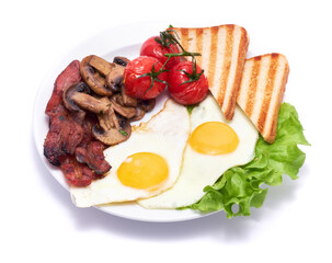 Fried eggs, bacon, tomato and toasted bread in ceramic plate isolated on white background
