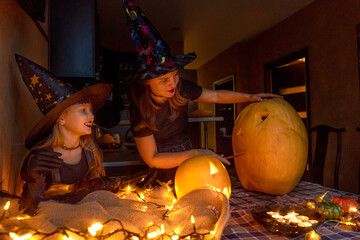 Mother daughter carving pumpkin. Preparing for halloween.