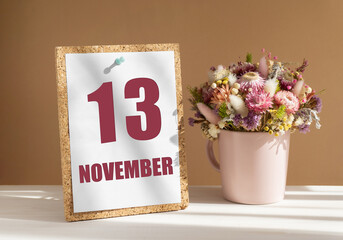 november 13. 13th day of month, calendar date.Bouquet of dead wood in pink mug on desktop.Cork board with calendar sheet on white-beige background. Concept of day of year, time planner, autumn month