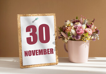 november 30. 30th day of month, calendar date.Bouquet of dead wood in pink mug on desktop.Cork board with calendar sheet on white-beige background. Concept of day of year, time planner, autumn month