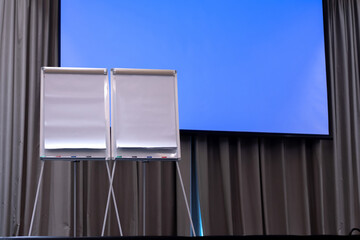 2 blank paper flip-charts on the stage