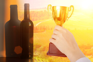 best wine award, bottle and goblet on the background of sunny vineyards, winery grape trophy