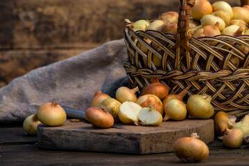 Fresh Red onion in basket on wooden table, top view, Organic food brown slices, still life rustic  raw cutting board outside wicker basket Bulb Food Ingredients local farmers market store