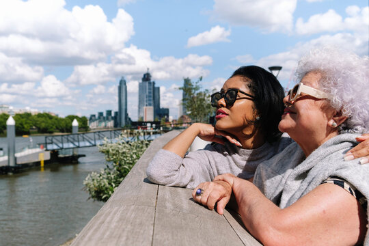 Mother and daughter standing at Battersea Bridge on sunny day