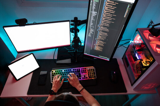 Computer programmer working on desktop PC at home