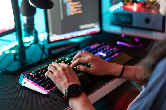 Man using keyboard in front of desktop PC at home