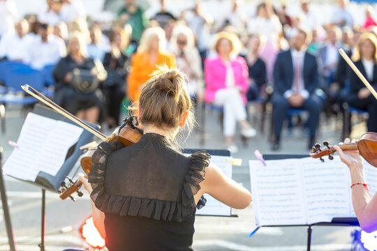 Musician Playing Violin At Classical Music Concert Or Outdoors Event In Front Of Blurred Audience